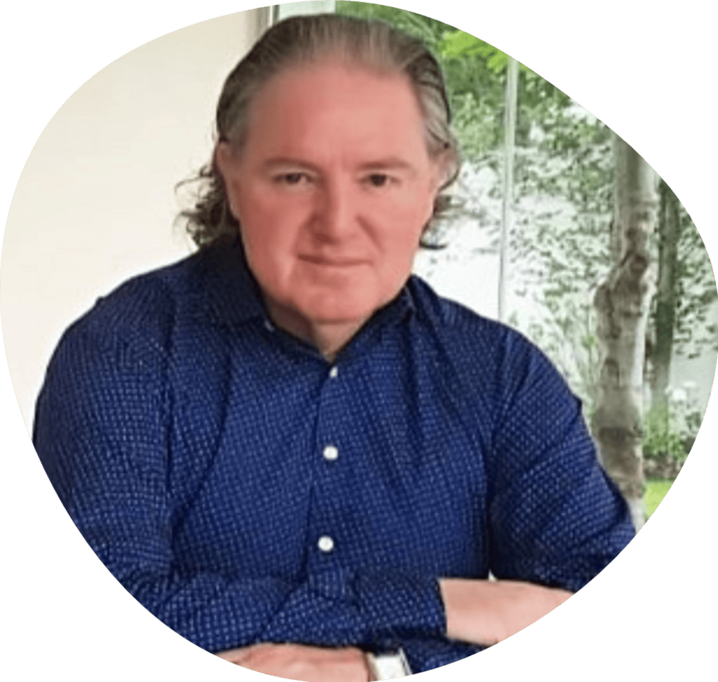 Godfrey O'Flaherty, CEO of the IIRFL and Global Custodian of Radical Forgiveness, sitting at a desk wearing a smart shirt