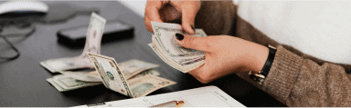 Person counting cash, symbolizing financial healing through radical forgiveness.