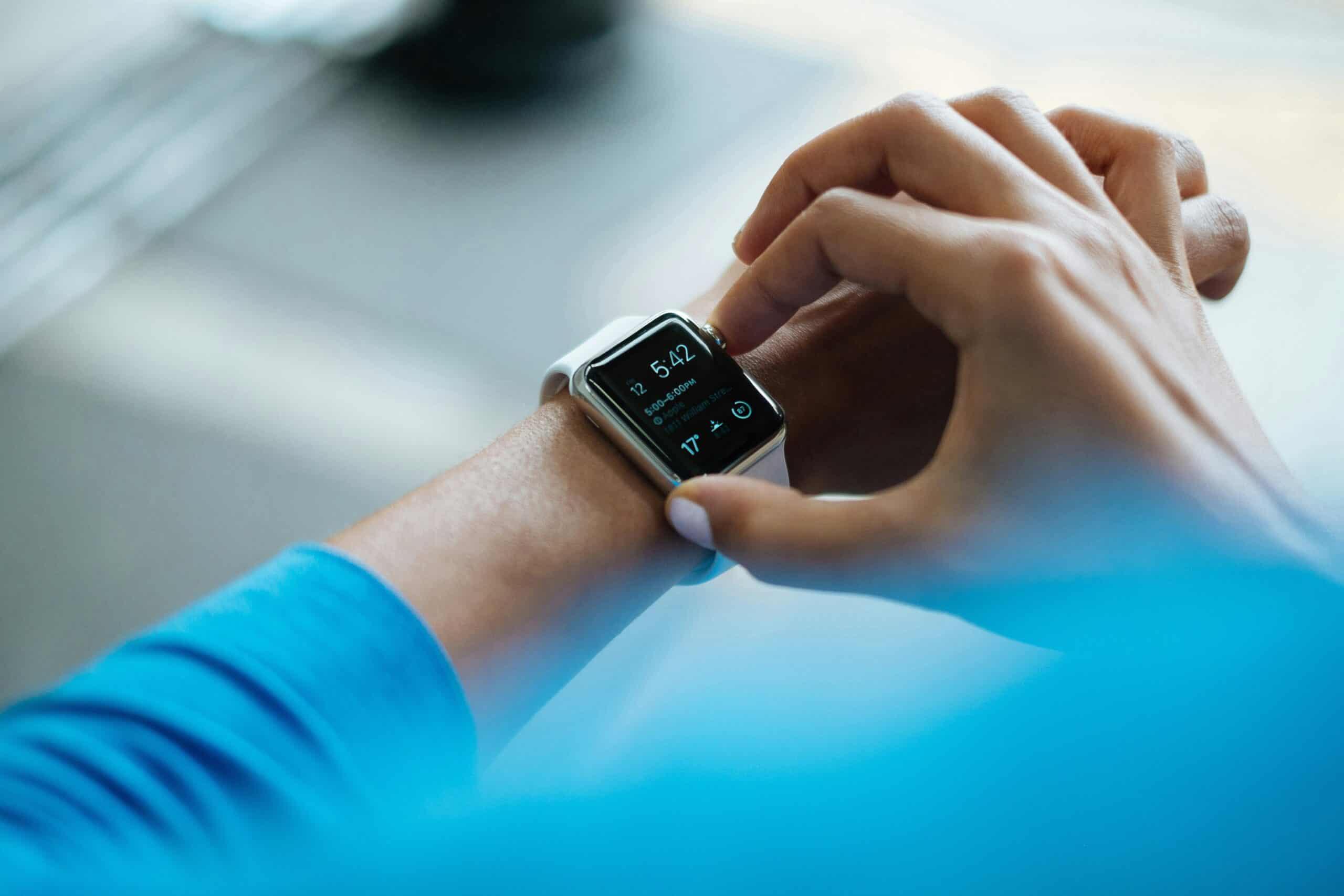 A female holding the controls and checking the readings on her fitness watch